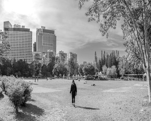 A person taking a relaxed walk in a city park