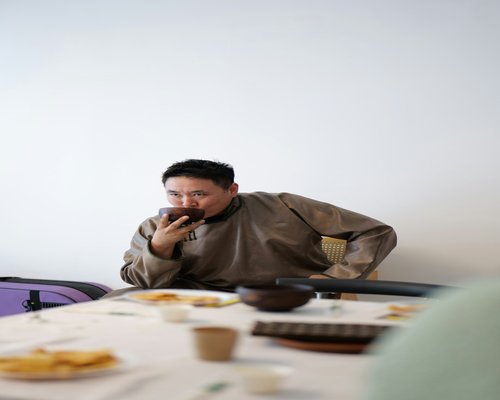 A person sitting at a table eating without rushing