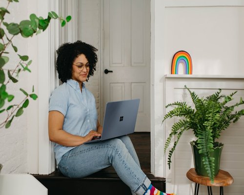 Person stepping away from laptop to look out the window